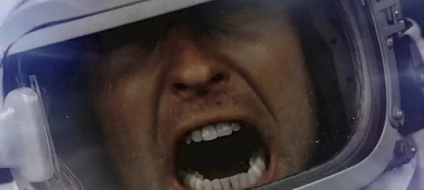 Astronauta enlouquecido gritando com o rosto em close.